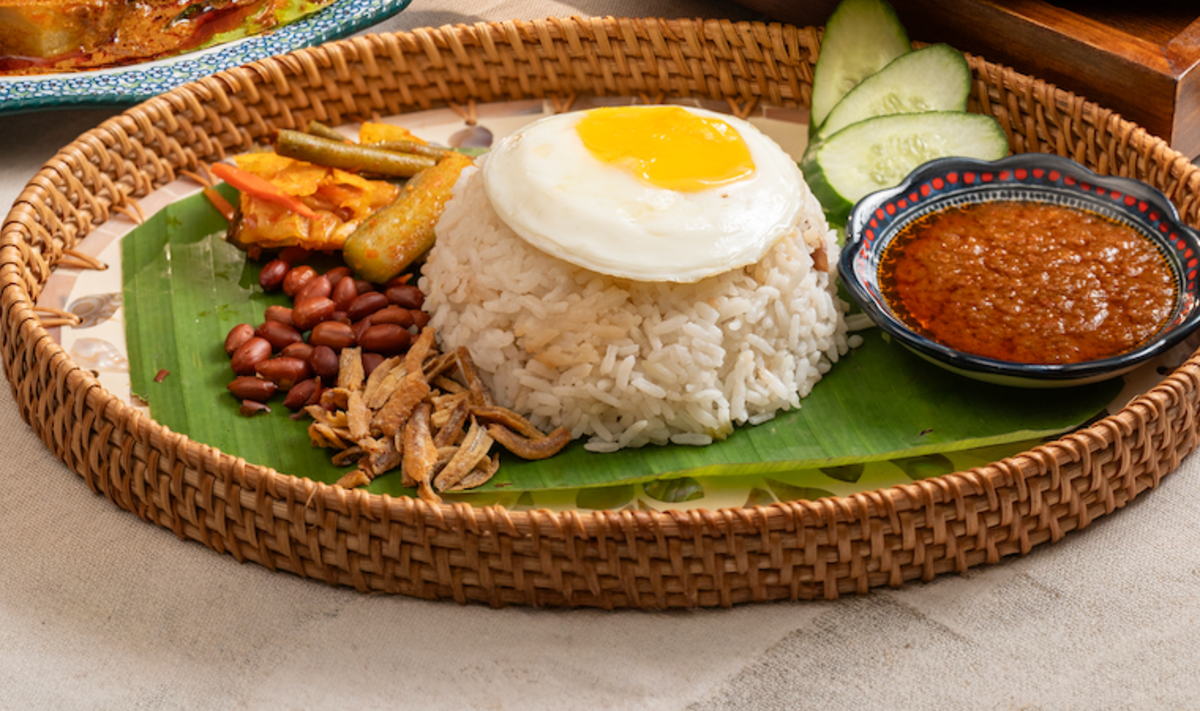 Classic nasi lemak on banana leaf with sambal, egg, peanuts and anchovies